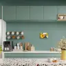 Modern kitchen interior featuring a sleek countertop with various kitchen utensils, a coffee machine, and a decorative cutting board. The backsplash is adorned with a vibrant photo canvas displaying sunflowers, adding a touch of colour. The kitchen has a clean, minimalist design with green cabinetry and a terrazzo countertop.