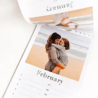 Personalised calendar displayed on a table alongside a coffee cup, featuring a heartwarming photo of a mom and daughter, blending perfectly into daily life and keeping cherished memories close.