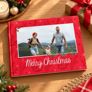 Christmas-themed photobook cover featuring a family walking on a beach. The design includes festive holly decorations and the text 'Merry Christmas' in red on a white background.