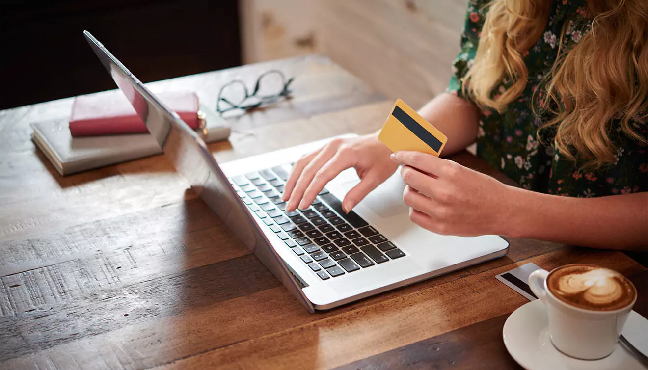 Close-up of a woman holding a credit card, preparing to make an online purchase for photo books or canvas prints