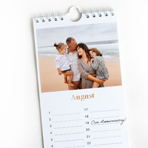 Personalised birthday calendar featuring a family photo for the month of August. The calendar has a spiral binding and a hook for easy hanging. Ideal for customising with special dates and anniversaries. Perfect as a thoughtful gift for various occasions, including birthdays and Christmas.