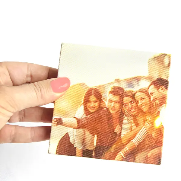 Hand holding a small square instablock featuring a group of friends taking a selfie. The photo block has a canvas texture and is ideal for personalised gifts, photo albums, or home decor.