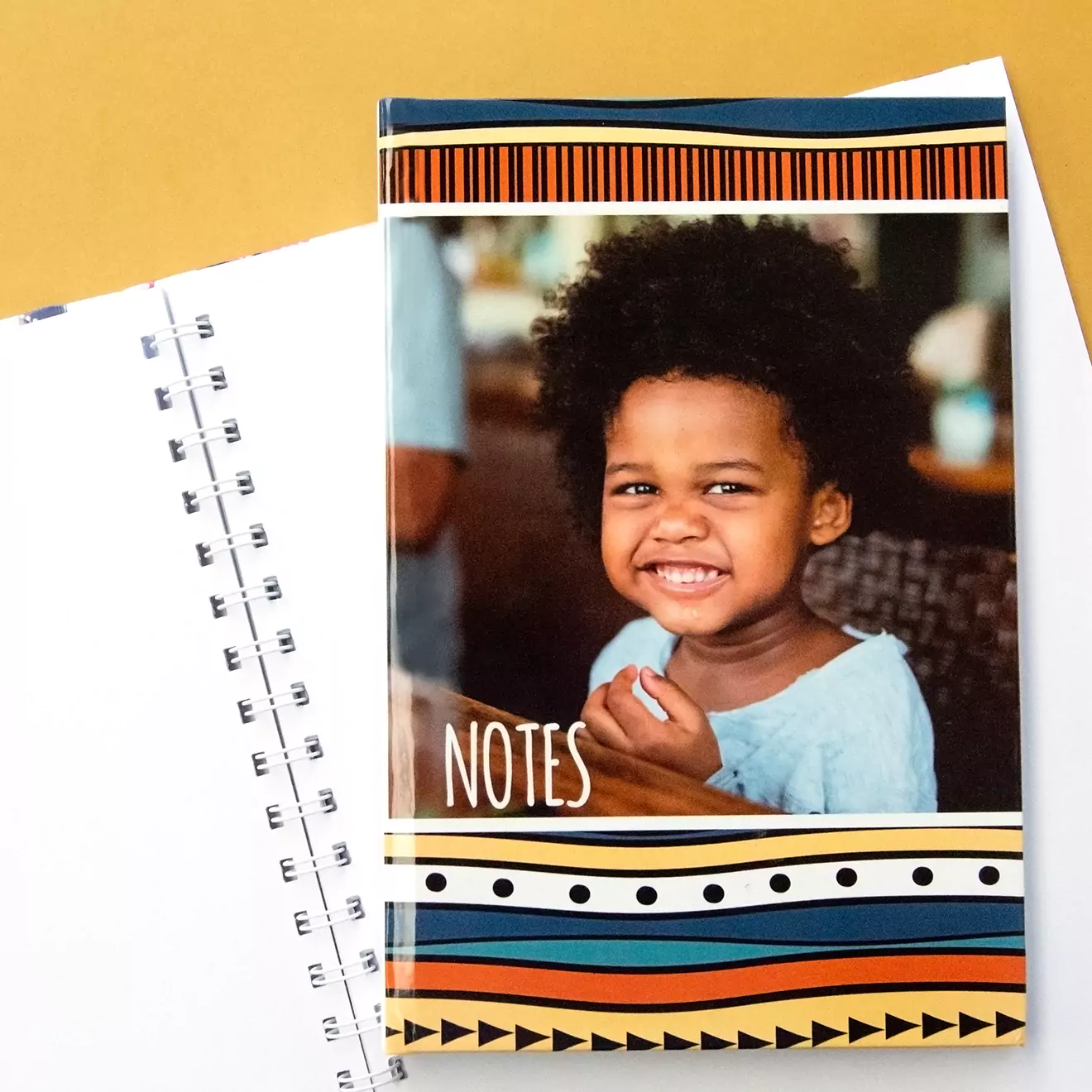 Colourful personalised notebook featuring a smiling child on the cover with the word 'Notes' and vibrant geometric patterns. Ideal for gifts, baby shower gift ideas, and personalised gifts in South Africa.