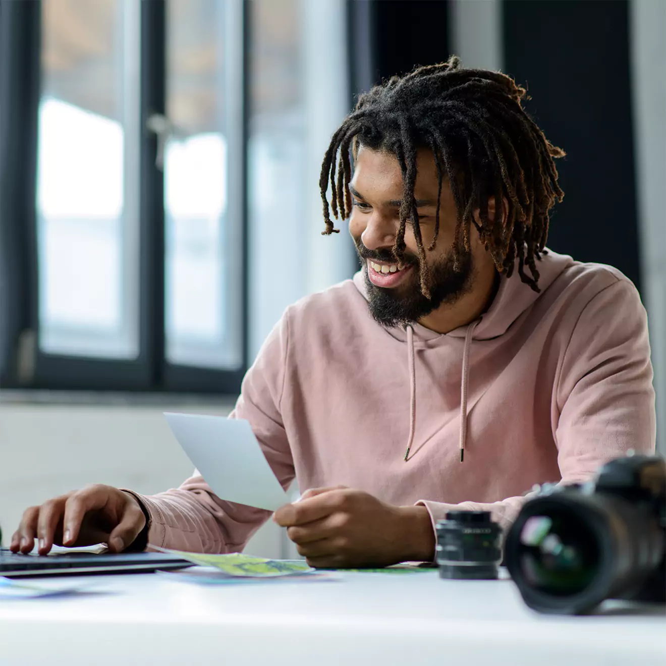 Photographer sitting at his desk, intently looking at prints, showcasing his dedication to his craft.