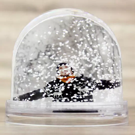 Personalised snow globe featuring a man dressed in warm clothes, captured inside with gently falling snow, creating a cozy and picturesque winter scene.