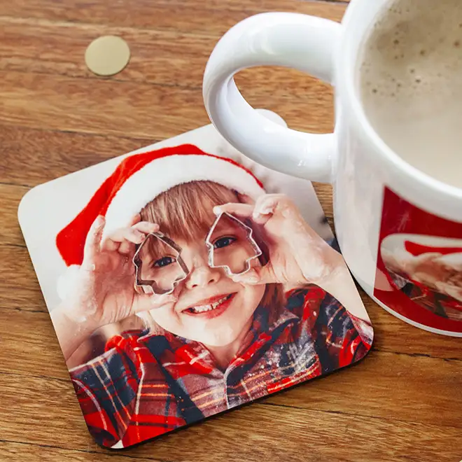 Personalised coaster featuring a child in a festive Christmas outfit, placed on a table next to a coffee mug, adding a seasonal and joyful touch to your holiday table setting.