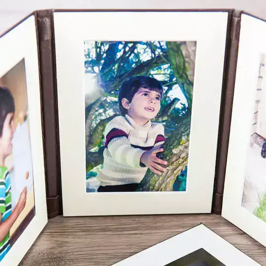 Tri-fold frame featuring three sequential photos of a child, capturing a series of memorable moments in a single elegant display, ideal for showcasing growth and milestones.