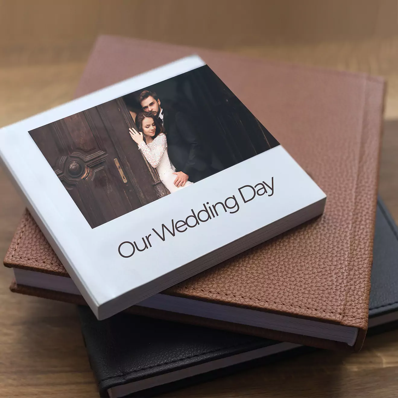 Stack of personalised photo albums with a white cover album on top featuring a wedding photo and the text 'Our Wedding Day.' Ideal for wedding memories, gifts for her, and personalised gifts in South Africa.