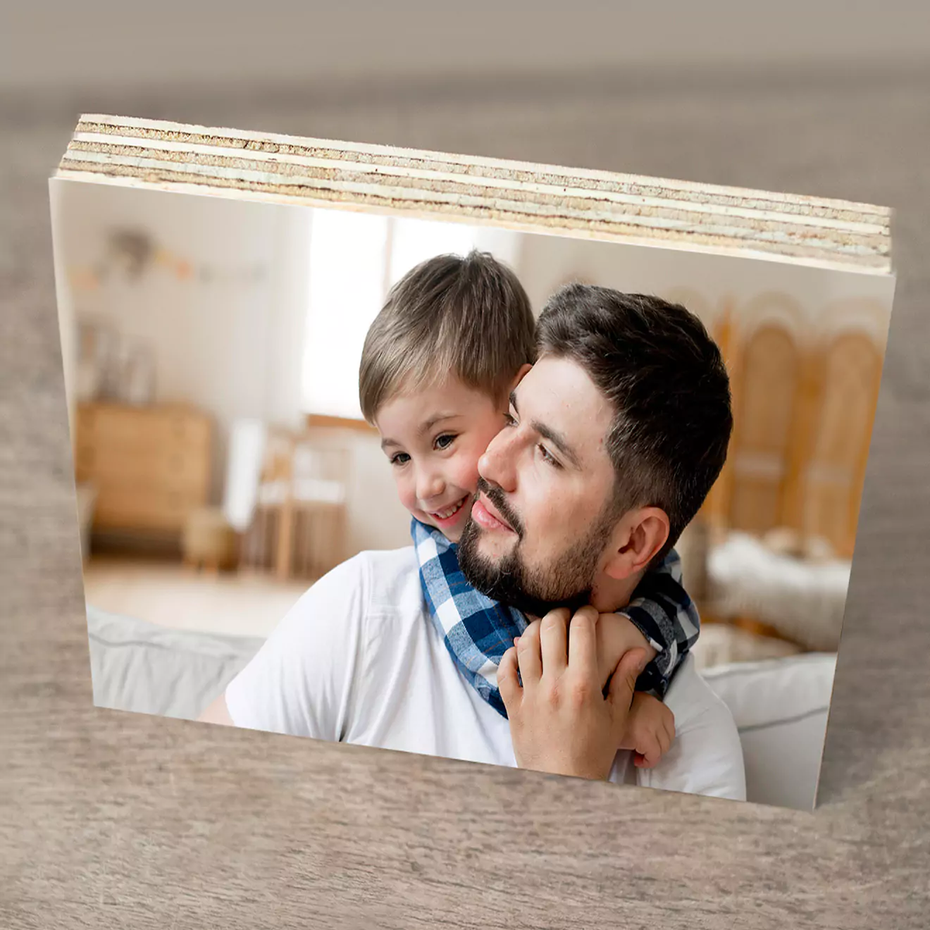 Wooden block photo print featuring a heartwarming image of a father and son sharing a joyful moment. The father is holding his son, who is smiling and hugging him from behind.