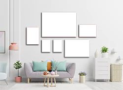 A stylish 6-piece canvas set displayed on a white wall above a modern grey sofa with pastel cushions. The canvases feature various abstract designs in shades of grey and red. The room is decorated with a white side table, plants, and minimalistic decor, creating a contemporary and inviting atmosphere. Ideal for personalised gifts in South Africa, photo to canvas, and home decor.