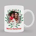 White ceramic Christmas-themed mug featuring a festive green wreath frame around a personalised photo. The mug displays the text 'Merry Christmas' in red below the photo. Ideal for Christmas gift ideas, personalised gifts in South Africa, and gifts for men or women.