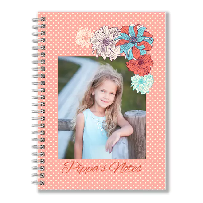 Spiral-bound notebook with a peach polka dot cover featuring a central photo of a young girl. The cover is adorned with colourful floral illustrations at the top and the text "Pippa's Notes" at the bottom. Ideal for personalised gifts, baby shower gift ideas, and Christmas gifts.