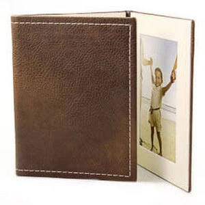 Tri-fold photo album with a brown leather cover and white stitching. The album is open, displaying a photograph of a child. Ideal for personalised gifts, baby shower gift ideas, or Christmas gifts. Suitable for storing cherished memories in a stylish and compact design.