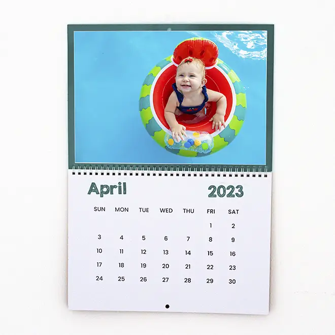 Personalised wall calendar for April 2023 featuring a colourful image of a smiling child in a pool float. The calendar has a clean, minimalist design with dates clearly marked. Ideal for gifts such as baby shower gift ideas, Christmas gifts, or personalised gifts in South Africa.