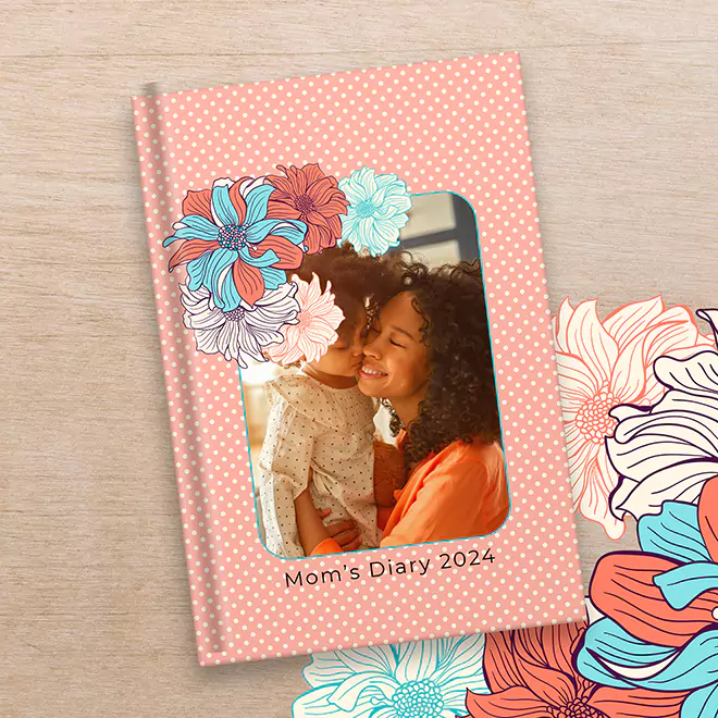 A5-sized personalised diary for 2024 with a peach polka dot cover featuring a floral design and a photo of a mother and child. The text 'Mom's Diary 2024' is printed at the bottom. Ideal for gifts for her, baby shower gift ideas, and personalised gifts in South Africa.