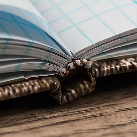 Close-up image of an open photo book showing the detailed binding and high-quality paper. The book lies on a wooden surface, highlighting its sturdy construction and elegant design. Ideal for personalised gifts in South Africa, photo albums, and special occasions like Christmas or Valentine's Day.