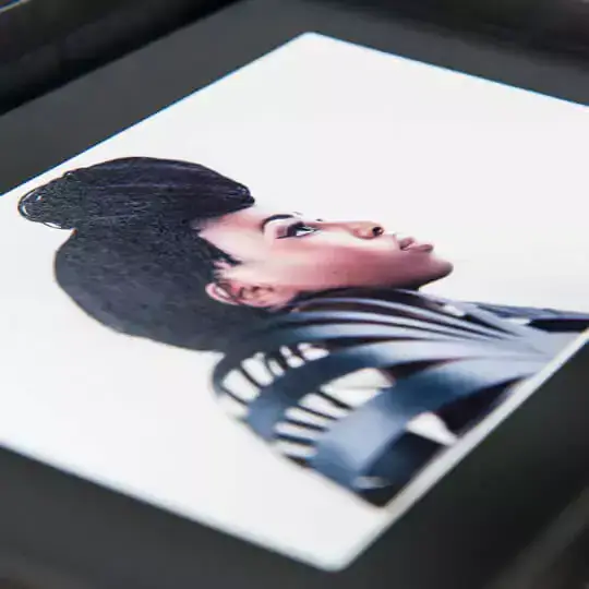 Close-up of a personalised photo book featuring a high-quality image of a person with an intricate hairstyle on the cover. The photo book has a sleek, black cover, making it an ideal gift for various occasions such as birthdays, Christmas, or Valentine's Day. Perfect for preserving cherished memories.