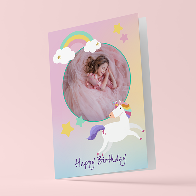 Personalised birthday card featuring a young girl in a pink dress, surrounded by whimsical elements like a rainbow, stars, and a unicorn. The card has ''Happy Birthday'' written in playful purple font. Ideal for children''s birthday celebrations and personalised gifts in South Africa.