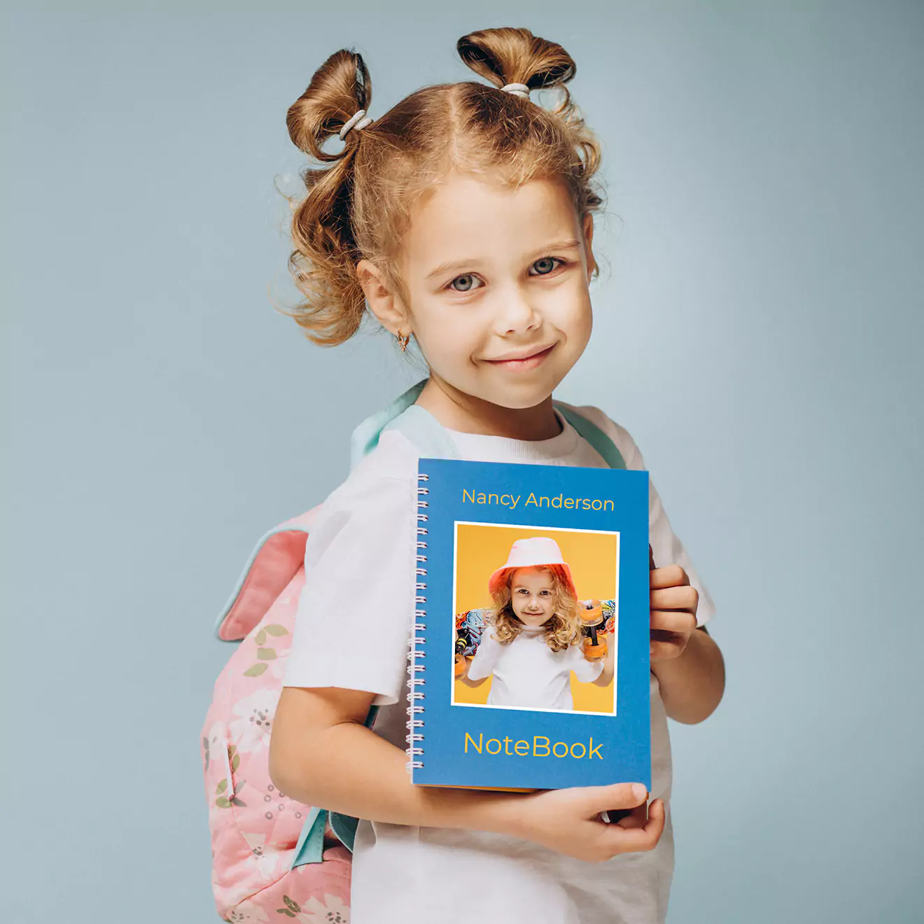 Young school girl holding a personalised notebook with a custom design, smiling and ready for school.