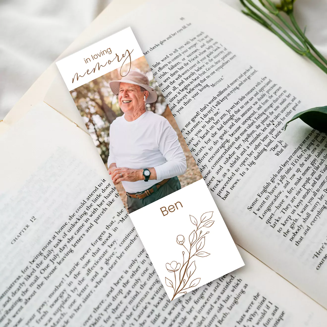 Personalised funeral memories bookmark featuring a smiling man in a white hat and shirt, placed inside an open book. Custom text reads 'In Loving Memory' with name and dates. Ideal for commemorating loved ones.