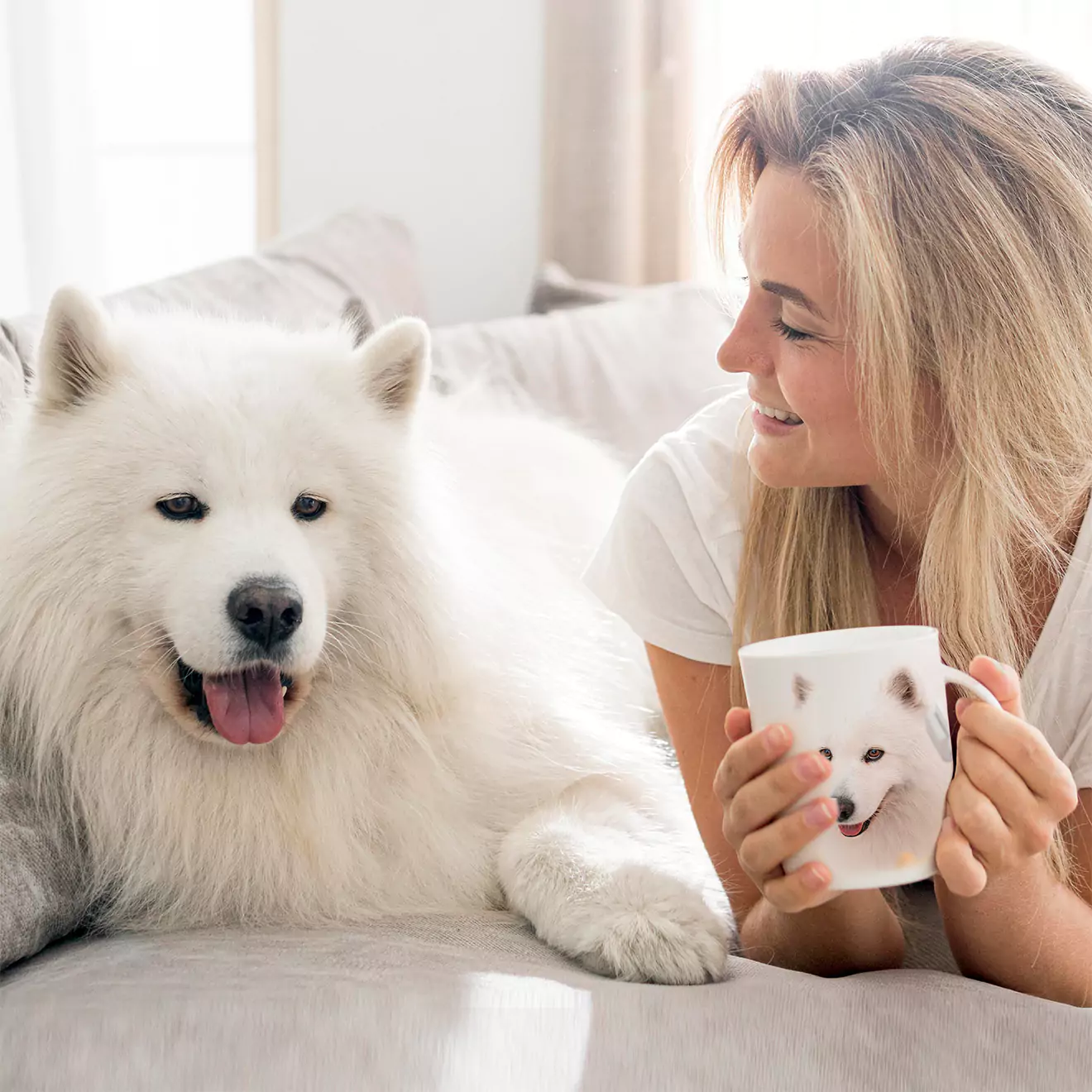 A joyful mum holding a pet-themed mug while looking lovingly at her dog. Perfect for Mother's Day, this personalised mug is an ideal gift for her, celebrating the bond between mums and their pets. Thoughtful gift ideas in South Africa.