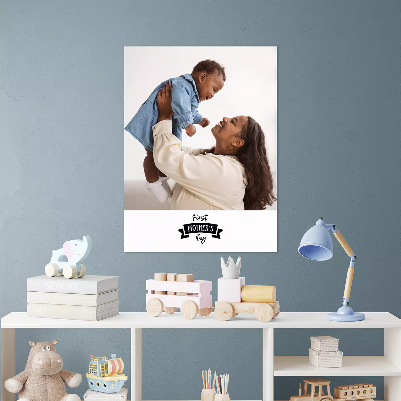 Image of a personalised canvas collage displayed on the nursery wall with an image of a mother adoringly looking at her baby, capturing a tender family moment and enhancing the room's decor.