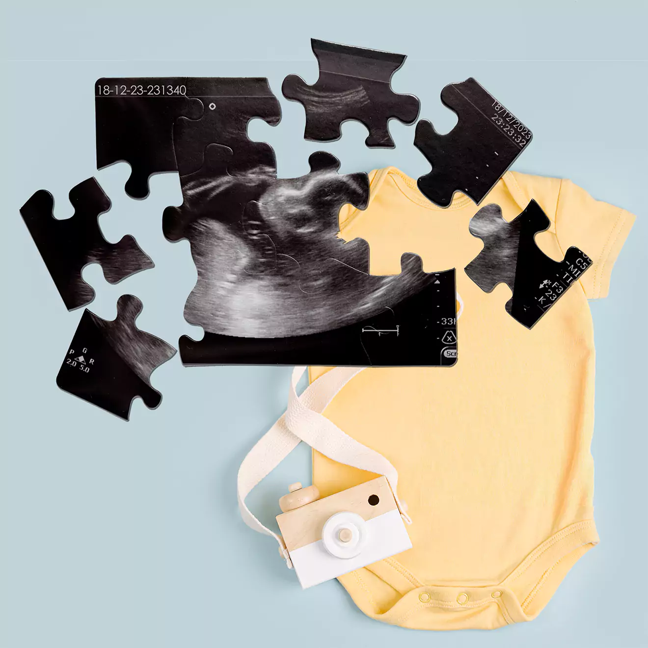 Image of a personalised puzzle featuring a baby scan, displayed next to a baby grower with the caption 'Gifts for baby'. Perfect for expectant parents to celebrate the upcoming arrival of their child in a unique and memorable way.