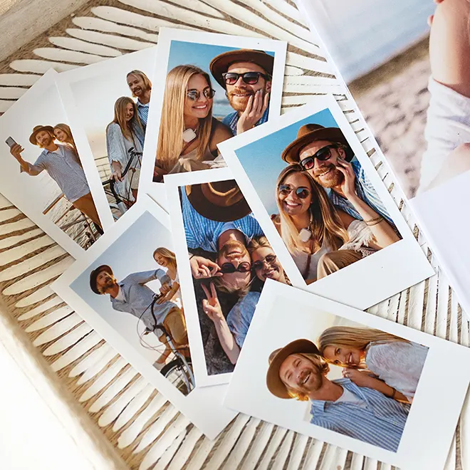 A collection of printed photo cards featuring a couple enjoying outdoor moments. The photos show the couple smiling, posing, and taking selfies in a sunny setting. The cards are laid out on a textured surface, showcasing vibrant colours and clear images. Ideal for personalised gifts, photo albums, or keepsakes.