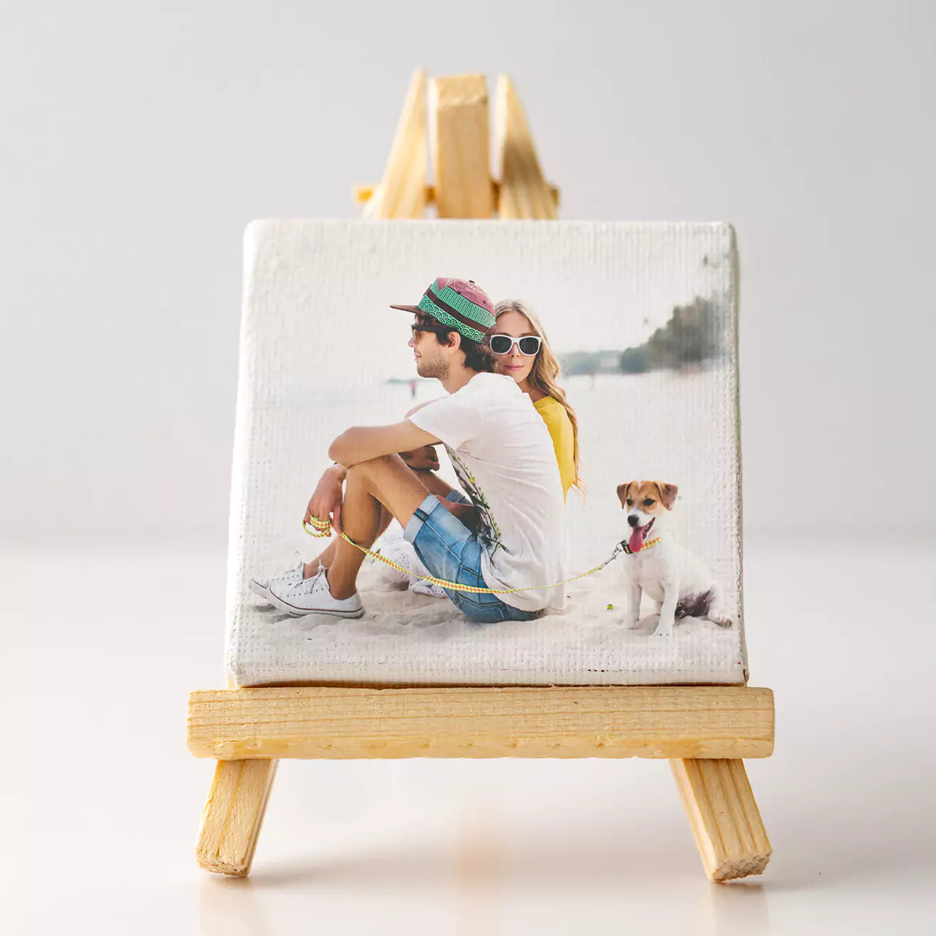 Personalised photo canvas print featuring a couple sitting on a beach with their dog, displayed on a small wooden easel. Ideal for gifts for men, Christmas gift ideas, or personalised gifts in South Africa. Perfect for home decor or as a unique photo to canvas gift.