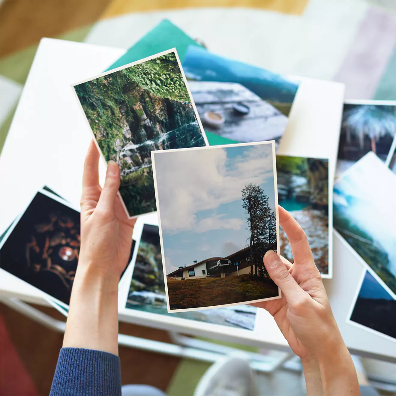 A collection of printed photographs featuring a pregnant woman in a yellow dress, a child in a white shirt with palm tree graphics, and a family portrait. The images are set against natural outdoor backgrounds, capturing warm, intimate moments. Ideal for personalised photo albums or gifts.