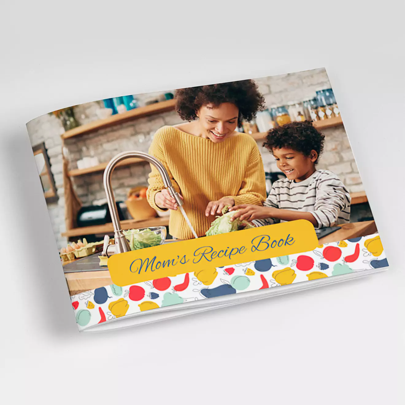 Personalised recipe book titled ''Mom''s Recipe Book'' featuring a colourful, polka dot design on the cover. The cover image shows a mother and child cooking together in a kitchen. Ideal for gifts for her, Christmas gifts, or baby shower gift ideas. Available on a South African photobooks printing e-commerce website.