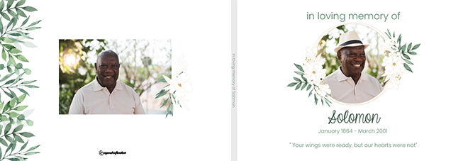 A personalised memorial photo book cover featuring a serene design with green foliage and white flowers. The front cover displays a circular photo of a smiling man with the text ''In loving memory of Solomon'' and dates. The back cover includes another photo of the same man. Ideal for commemorating loved ones.