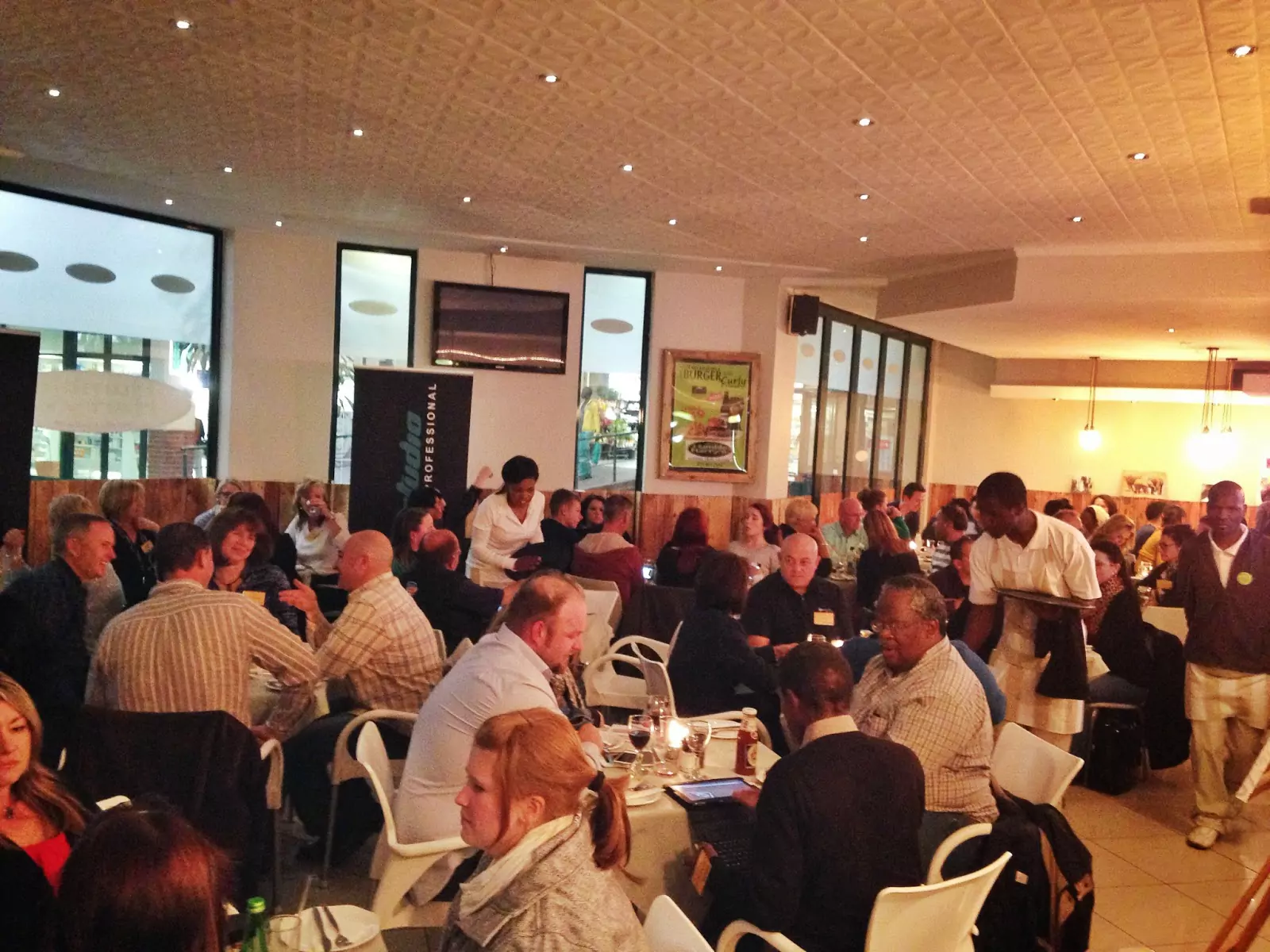 Audience seated at tables during a RapidStudio event featuring Andrew Ross