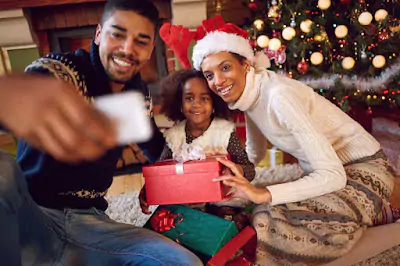 Happy family smiling in front of a beautifully decorated Christmas tree.