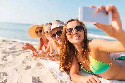 Young ladies on the beach taking a selfie, enjoying the sunny day