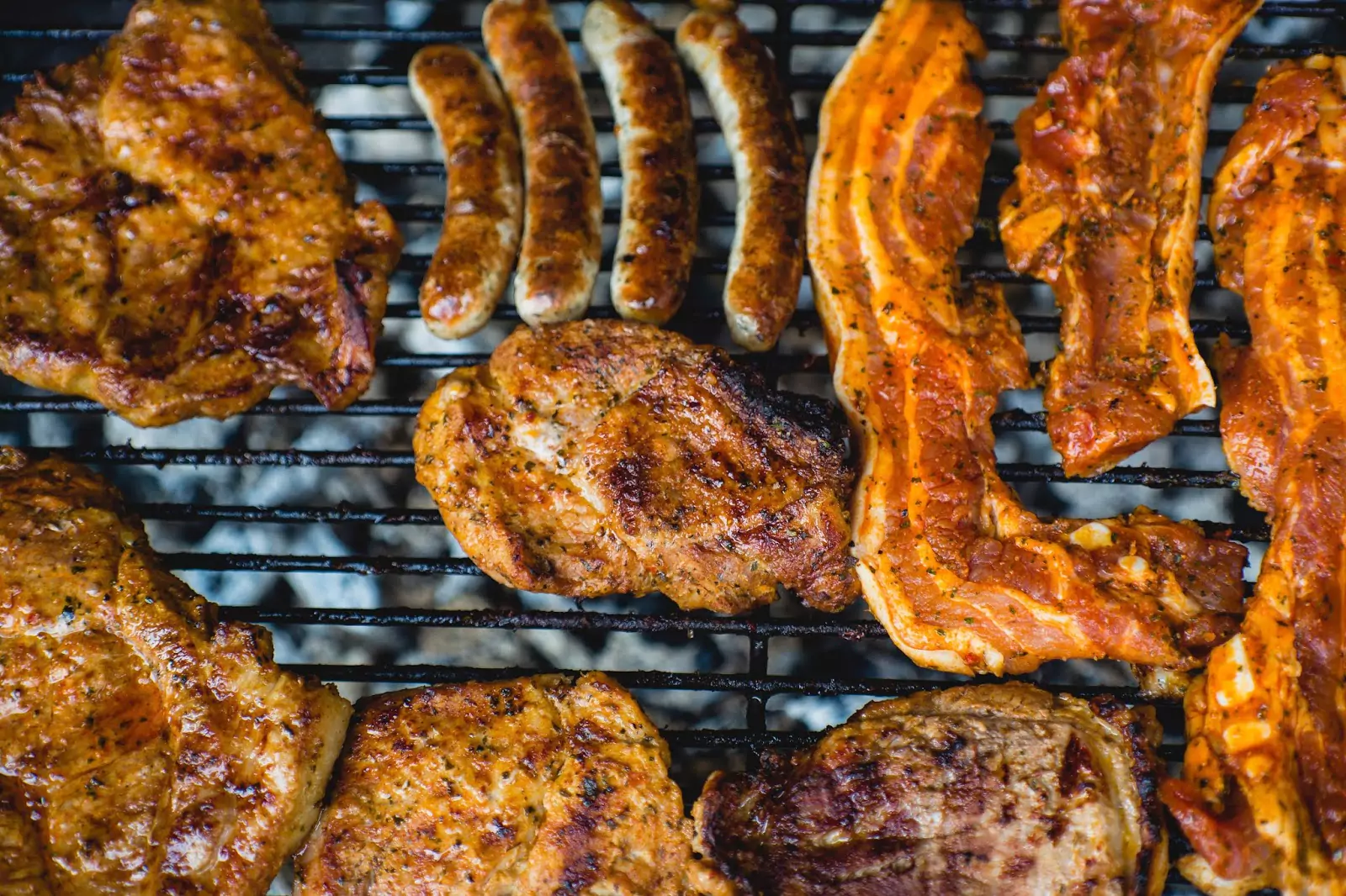 A large amount of meat sitting on the braai, being cooked