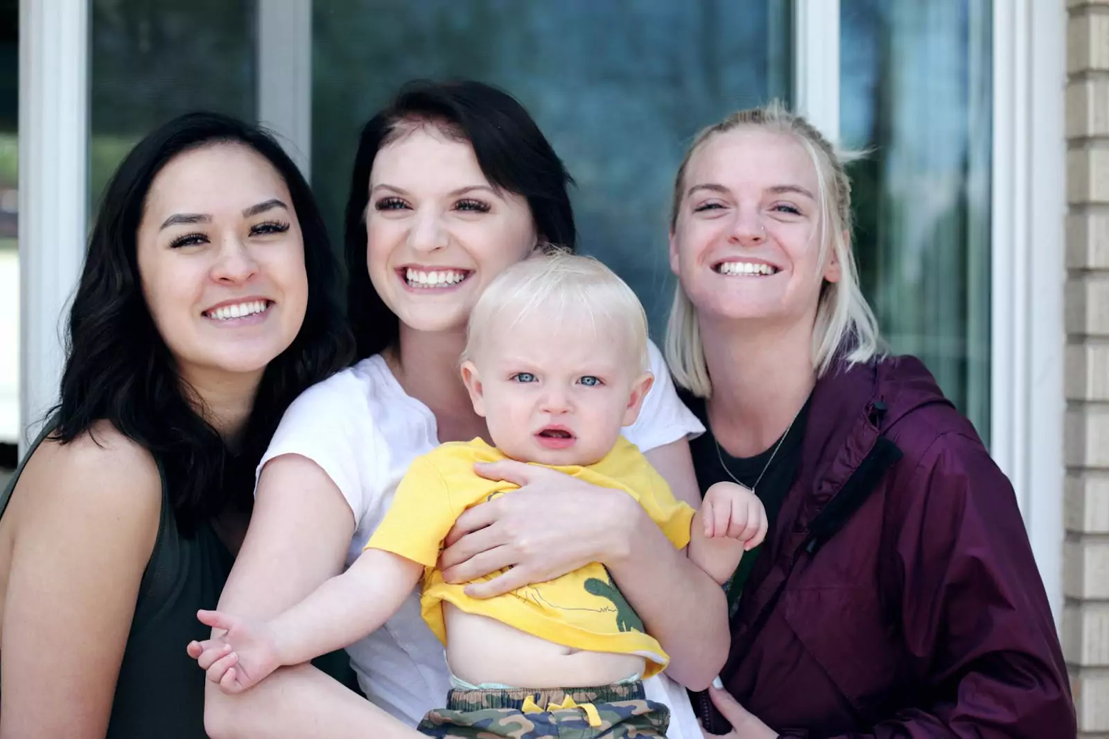 Photo of three loving sisters with a child, capturing a special family moment