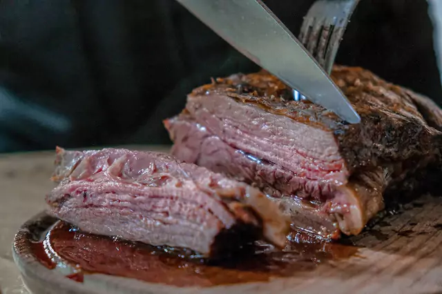 Close-up of a juicy rare steak being cut with a knife