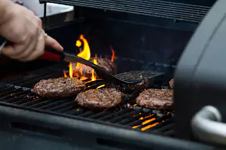 Man cooking meat on a traditional South African braai