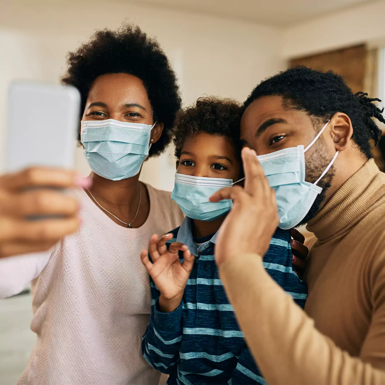 Family taking a selfie with masks on during the COVID-19 pandemic