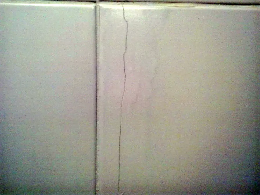 Large crack on a wall, ready to be covered up with a canvas for a seamless look