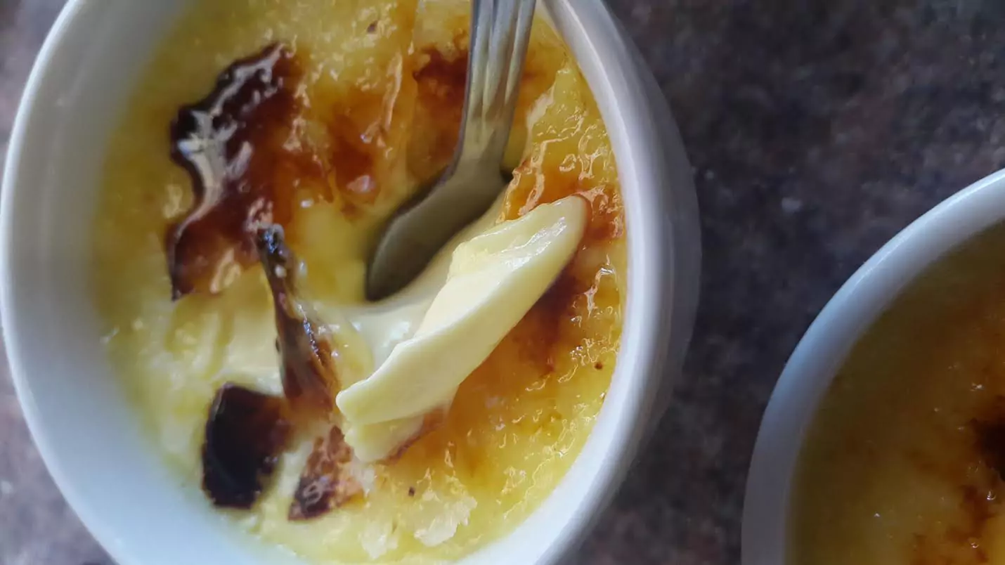 Close-up shot of crème brûlée in a teacup, highlighting the caramelised top and creamy texture