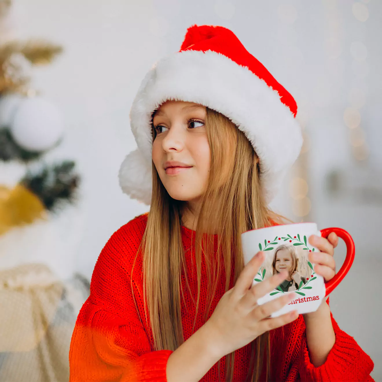 Young girl in a Christmas outfit holding a festive Christmas mug