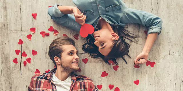 Inspirational Valentine's banner featuring a couple lying on the floor with hearts surrounding them, capturing love and connection