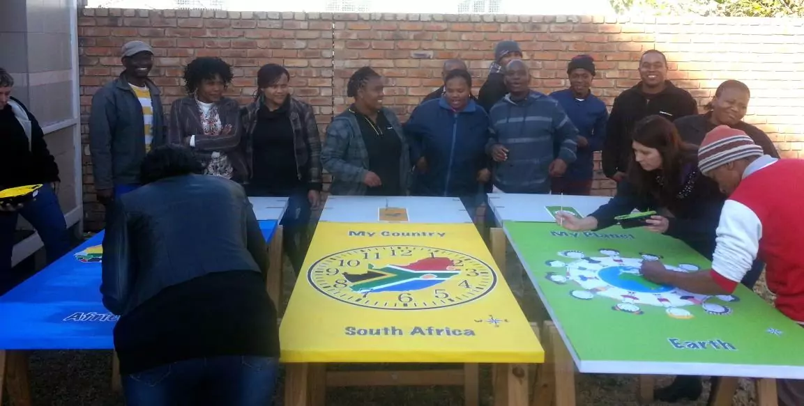 Whole crowd of RapidStudio staff working together to create large canvases in celebration of Nelson Mandela International Day, fostering teamwork and creativity