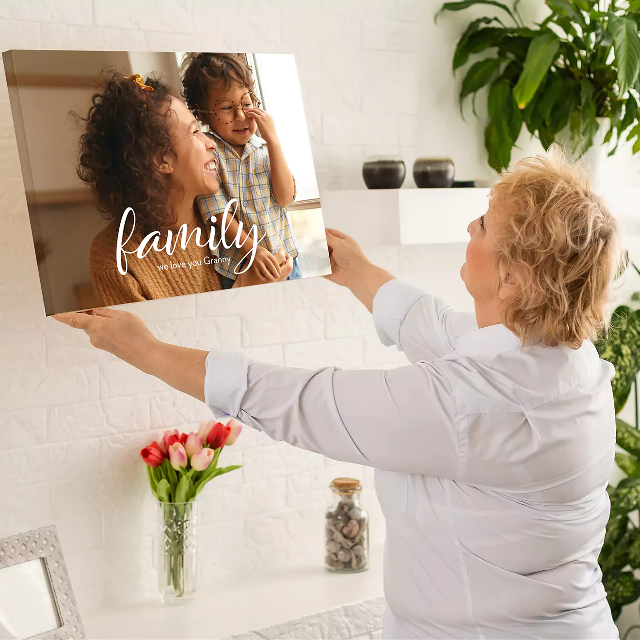 Mom hanging a personalised family canvas on her wall, adding a personal touch to her home decor