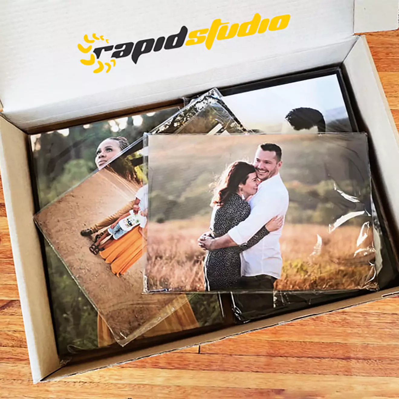 Box of photo goodies from RapidStudio, part of a "Share to Win" giveaway, showcasing exciting photography products