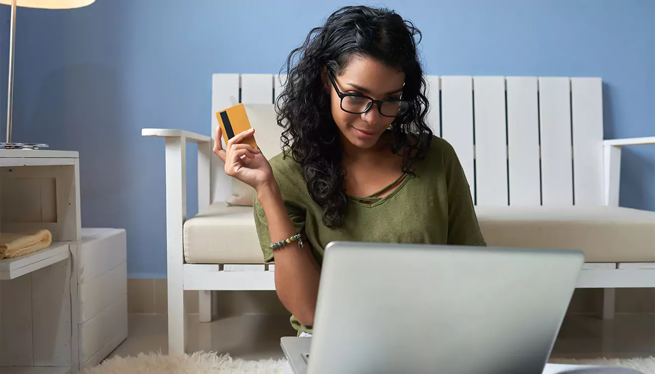 Woman holding a credit card, preparing to make an online purchase for photo books or canvas prints - banner