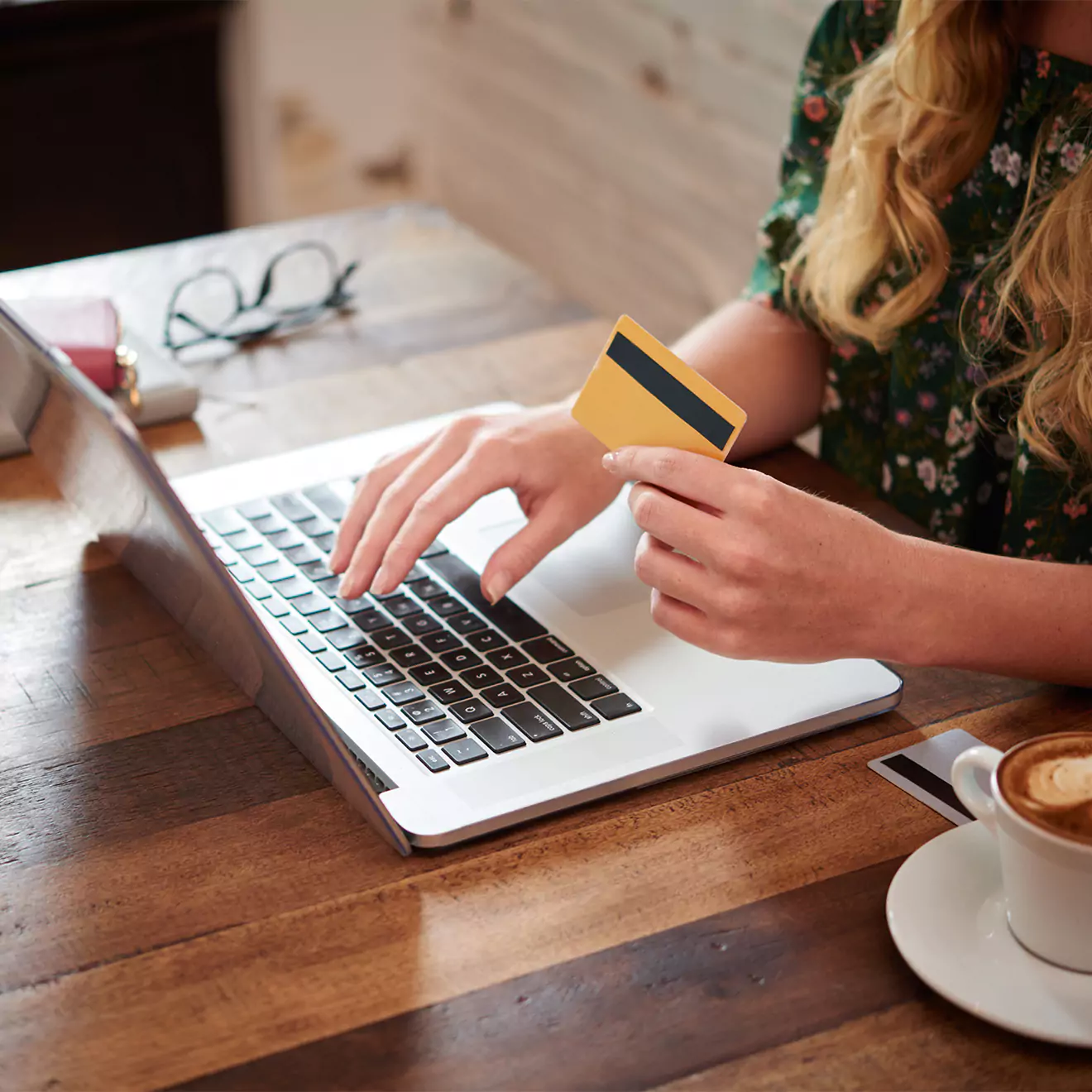 Close-up of a woman holding a credit card, preparing to make an online purchase for photo books or canvas prints