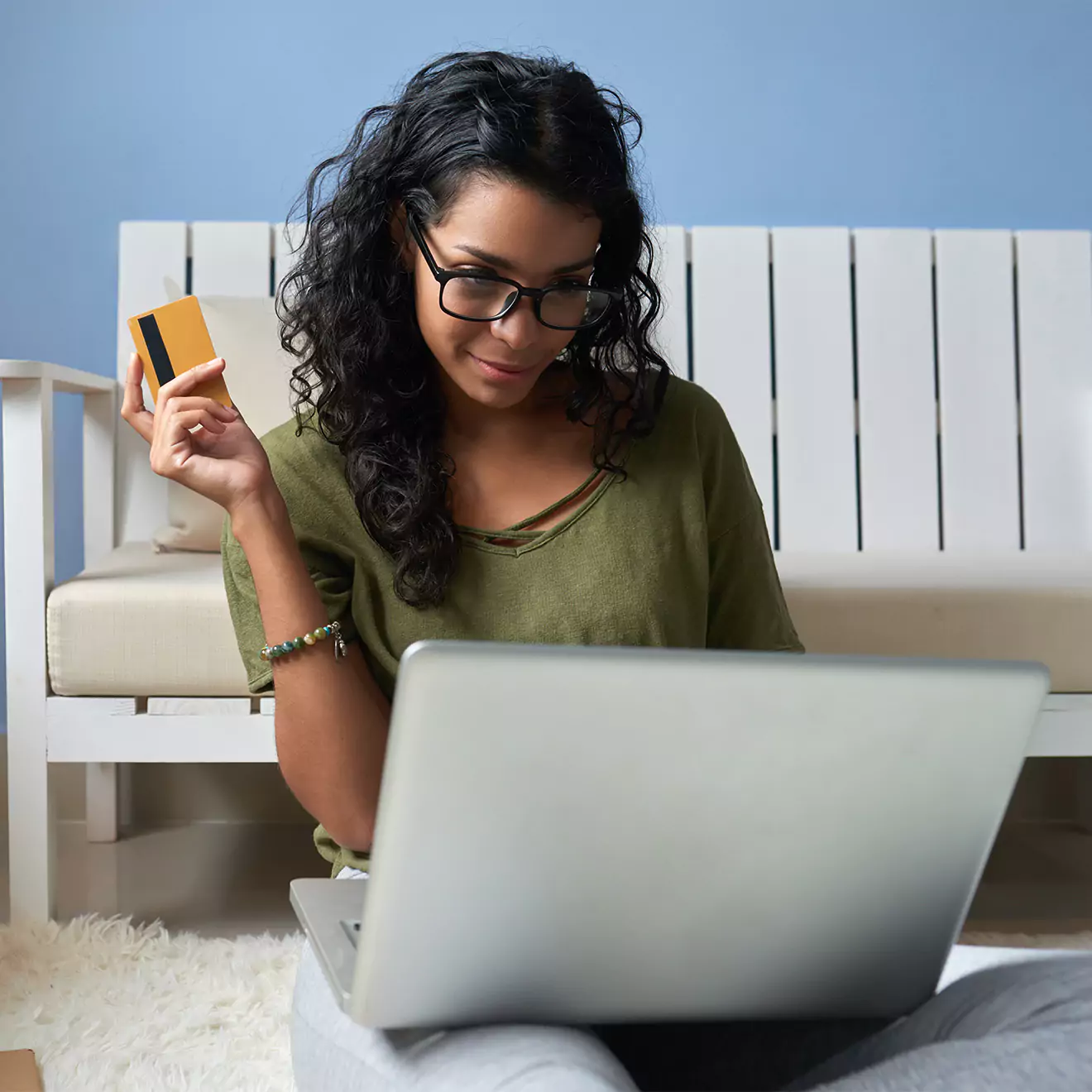 Woman holding a credit card in her hand, about to make an online shopping purchase for photo books or canvas prints